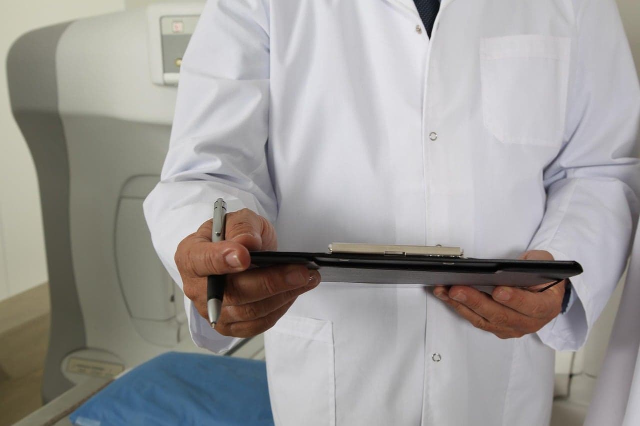 A clinician holds a clipboard and pen