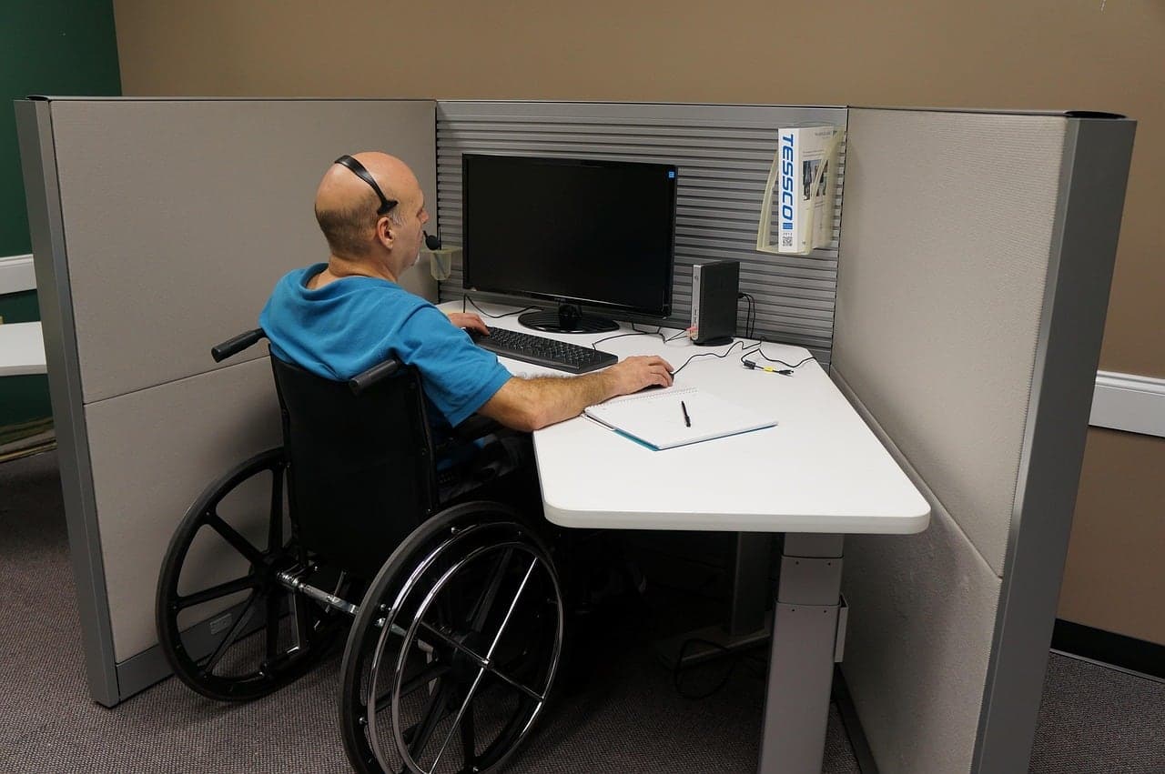A support agent wearing a headset works at his desk
